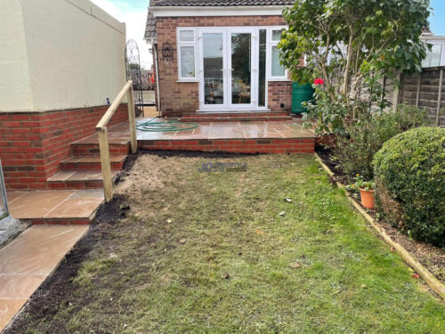 Raised Indian Sandstone Patio with Brick Retaining Wall and Steps in Ashford, Kent