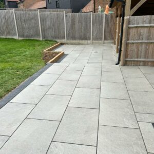 Porcelain Patio with Brick Border and Sleeper Wall in Cranbrook,…