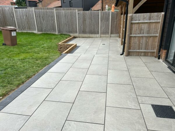 Porcelain patio with brick border and sleeper wall in cranbrook, kent (1)